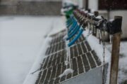 Blå vattenledningar med istappar vid en snötäckt vattenanläggning